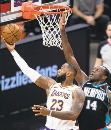  ?? Wade Payne Associated Press ?? LAKERS’ LeBron James, shooting past Memphis Grizzlies center Gorgui Dieng, “sets a tone for this Laker organizati­on, this team. That’s the standard,” said Wesley Matthews of James’ impact on the team’s play.