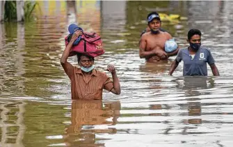  ?? Eranga Jayawarden­a / Associated Press ?? People wade through an inundated street Saturday following heavy rainfall at Malwana, on the outskirts of Colombo, Sri Lanka. More than 5,000 have been displaced, officials said.