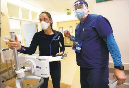  ?? Francine Orr Los Angeles Times ?? VANESSA HARPER of Behavioral Health Services and Dr. Brian Boyd enter an exam room at Providence St. Joseph in Orange.