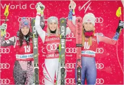  ?? JEFF McINTOSH, THE CANADIAN PRESS ?? Gold medallist Cornelia Huetter of Austria, centre, celebrates on the podium with runner-up Tina Weirather, left, and third-place finisher Mikaela Shiffrin, at Lake Louise, Alta., on Friday.