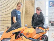  ?? SAM MCNEISH/THE TELEGRAM ?? Students who attended school at Waterford Valley High School in St. John’s on Monday couldn’t miss the bright orange motorcycle that was on display in the school’s lobby as they entered the building. Grade 10 students Carter Corcoran (left) and...