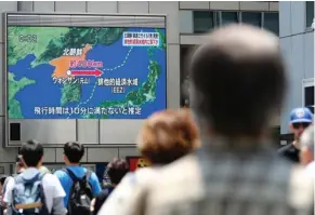  ?? (Meika Fujio/Kyodo News via AP) ?? People walk near a screen which reports North Korea’s missile launch, in Osaka, western Japan Monday, May 29, 2017. North Korea fired a short-range ballistic missile that landed in Japan’s maritime economic zone Monday, officials said, in the latest in...
