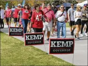  ?? CURTIS COMPTON/CCOMPTON@AJC.COM ?? Supporters of Secretary of State Brian Kemp hold a rally as Georgia fans make their way to Sanford Stadium to play South Carolina on Saturday in Athens.