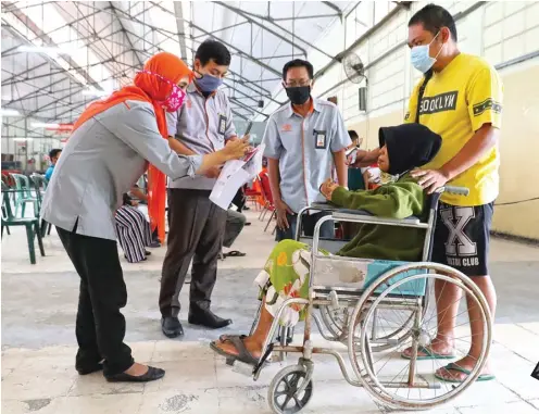  ?? FRIZAL/JAWA POS ?? PENERIMA HARUS HADIR: Warga Pabean Cantian Kusdjayani datang ke Kantor Pos Kebon Rojo dengan menggunaka­n kursi roda untuk menerima bantuan tunai kemarin.
