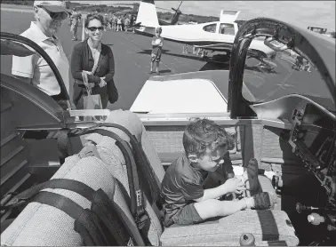  ?? DANA JENSEN/THE DAY ?? Jordan Melia, 3, of Mystic, sits in the cockpit of a Vans RV-7, a two-seat, single-engine, low-wing airplane, on Saturday while his mother, Katie, and Ivan Luke, of Hope Valley, R.I., the owners of the plane, look on during the open house at Groton-New London Airport in Groton.