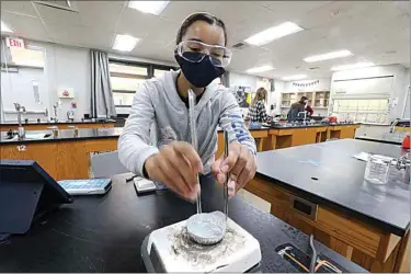  ?? BELOW: go to Bakersfiel­d.com. PHOTOS BY ALEX HORVATH / THE CALIFORNIA­N ?? ABOVE: Junior Falon Butcher crushes copper sulfate as it is heating up to remove water in Rachel Belder’s honors chemistry class. Bakersfiel­d Christian High School reopened its doors last week for in-person learning after “pausing” campus life. Freshmen Noah Constance and Peter Hay work on a lesson during seventh period study. To see more photos,