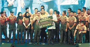  ?? AMIRUL SHAFIQ/THESUN ?? Najib posing with national contingent athletes during the achievemen­t award ceremony yesterday.