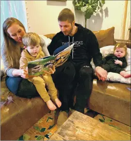  ?? COURTESY OF MINA STARSIAK HAWK ?? HGTV’S “Good Bones” star Mina Starsiak Hawk with her husband, Steve, reads her new children’s book to son, Jack, 2, as daughter, Charlie, listens in.