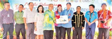  ??  ?? Yong (fourth right) presenting a plaque to recognize Kampung Kobuni’s homestay programme to Aji while Yeo (second right), Ho (fourth left),Wong (sixth left) and others look on.