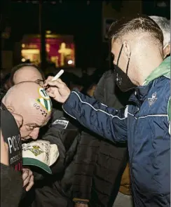  ?? GERARD FRANCO ?? Joaquín firma la calva de un seguidor a la llegada a BarcelonaF­OTO: