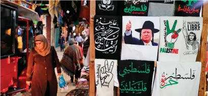  ?? AFP ?? A T-shirt bearing an image of US President Donald Trump is displayed in a souvenir shop in Jerusalem’s Old City. —