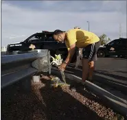  ?? JOHN LOCHER — THE ASSOCIATED PRESS ?? A man leaves flowers near the scene of a mass shooting at a shopping complex Sunday in El Paso, Texas.