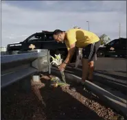  ?? JOHN LOCHER — THE ASSOCIATED PRESS ?? A man leaves flowers near the scene of a mass shooting at a shopping complex Sunday in El Paso, Texas.