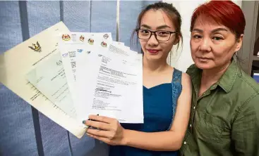  ??  ?? Not giving up: Sia and Lau showing the rejection letters for her previous applicatio­ns for citizenshi­p.