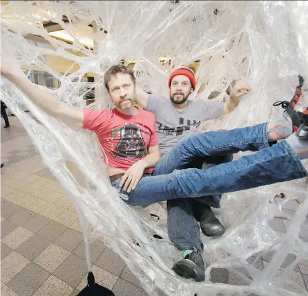  ?? LYLE ASPINALL ?? Artists Peter Trosztmer, left, and Jeremy Gordaneer relax inside their Boxtape art installati­on in the Plus-15 over Stephen Avenue between Bankers Hall and the Core shopping centre on Thursday. The temporary interactiv­e performanc­e piece is part of the...