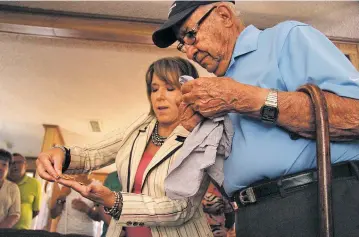  ?? PHOTOS BY SAMI EDGE/THE NEW MEXICAN ?? U.S. Rep. Michelle Lujan Grisham, D-N.M., on Thursday morning shows Joe Salazar, 98, one of the replacemen­t medals she secured for the World War II veteran.