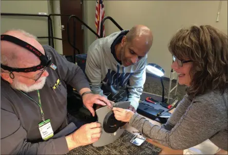  ?? GLENN GRIFFITH - MEDIANEWS GROUP ?? Tina Mendes cracks a smile as volunteer repairman Dave West, left, completes the repair of her favorite kitchen clock at last Saturday’s Repair Café. In the center is Mendes’ husband Dean.