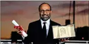  ?? AFP ?? Iranian director Asghar Farhadi poses with the Grand Prix award for his film ‘A Hero’ during the closing ceremony of the 74th Cannes Film Festival in Cannes, south of France, on July 17, 2021.