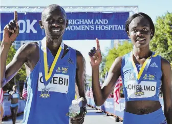  ?? HERALDPHOT­OJOSEPHPRE­ZIOSO ?? FAST FRIENDS: Daniel Chebii and Joan Chelimo pose together at the finish line after winning the men's and women's races at the BAA 10K yesterday.