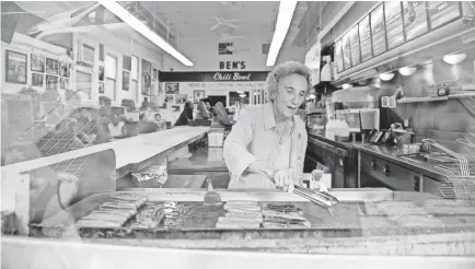  ?? CAMILLE FINE/USA TODAY ?? Virginia Ali, 85, owner and co-founder of Ben’s Chili Bowl, rotates hotdogs on the grill to be served to customers. Virginia and her husband, Ben, who died in 2009, opened the business in August 1958, and it is still thriving.