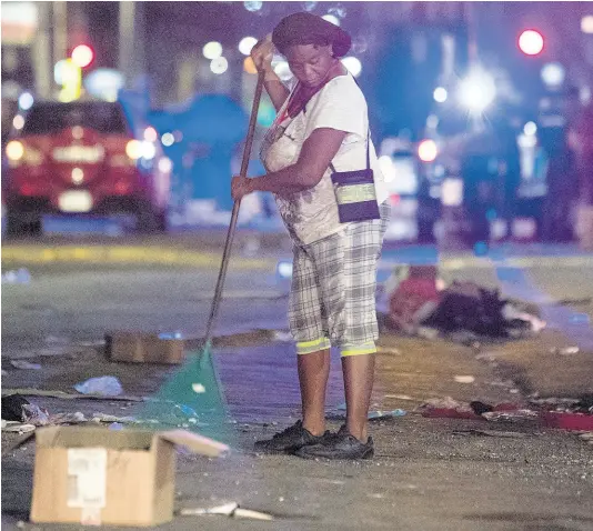 ?? FILE ?? A woman cleans the streets of downtown Kingston on April 1 last year, minutes after an islandwide curfew took effect. Low-income earners are finding it difficult to abide by isolation and quarantine protocols, pointing out that they cannot a cut in their wages.