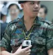  ?? — Reuters ?? A Thai military personnel uses a video camera to make a record of visitors at an entrance of the Phramongku­tklao Hospital in Bangkok.