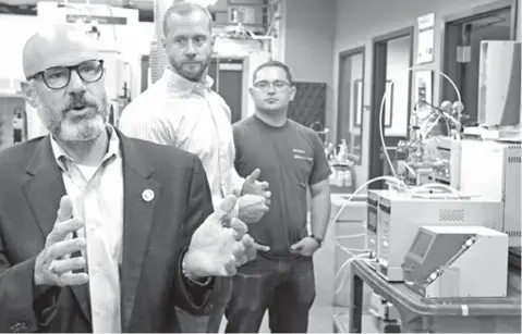  ?? Louis DeLuca/The Dallas Morning News via AP ?? ■ University of North Texas chemistry professor Guido Verbeck, left, talks about a breathalyz­er that will test for drugs on Aug. 9 as Tim Wing, InspectIR co-founder/managing director, center, and UNT graduate student Tom Kiselak, right, listen in Denton, Texas.