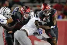  ?? Tim Warner ?? UH running back Duke Catalon, right, runs into Memphis’s Jonathan Wilson in the first quarter Thursday night. Catalon finished with a career-best three rushing touchdowns.