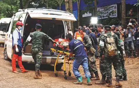  ?? AFP ?? Thai rescue workers practice medical drills on a dirt road leading to the Tham Luang cave, in Chiang Rai province on Saturday, as rescue operations continue for a missing children’s football team and their coach.