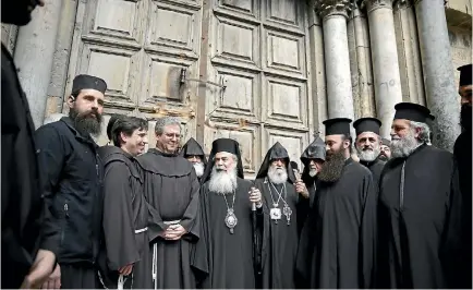  ?? PHOTO: AP ?? Greek Orthodox Patriarch of the Holy Land Theophilos III, centre, stands outside the closed doors of the Church of the Holy Sepulchre. The leaders of the major Christian sects in Jerusalem closed the church for several hours to protest an Israeli plan to tax their properties.