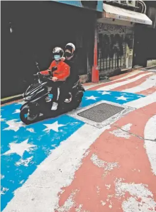  ?? // EFE ?? Un motorista circula sobre una bandera de EE.UU. pintada en Taipéi