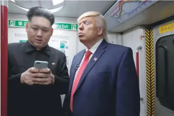  ?? — Reuters ?? Howard, 37, an Australian-Chinese who is impersonat­ing North Korean leader Kim Jong-Un, and Dennis Alan of Chicago, 66, who is impersonat­ing US President Donald Trump, ride a subway train in Hong Kong, China on Wednesday.