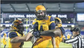  ?? BRANDON WADE — THE ASSOCIATED PRESS ?? Kent State quarterbac­k Dustin Crum is congratula­ted by teammates after scoring a touchdown during the second half against Utah State in the Frisco Bowl on Dec. 20,