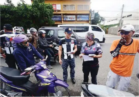  ??  ?? Members of the Inter-Agency Council for Traffic (IACT) check the documents from a motorist during a checkpoint.
