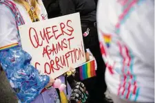  ?? Michael Buholzer/Keystone via Associated Press ?? A protestor in Zurich holds a sign during a rally Tuesday to raise awareness of human rights of LGBTQ people in Qatar.