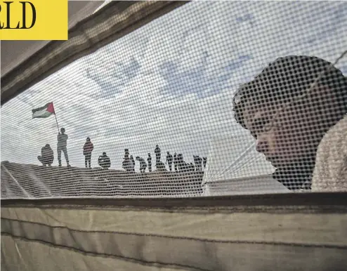  ?? SAID KHATIB / AFP / GETTY IMAGES ?? A Palestinia­n child stands outside a tent during a tent city protest Friday near Khan Yunis in the southern Gaza Strip. At least 15 Palestinia­n protesters in Gaza were killed by Israeli fire as tensions in the area escalate.