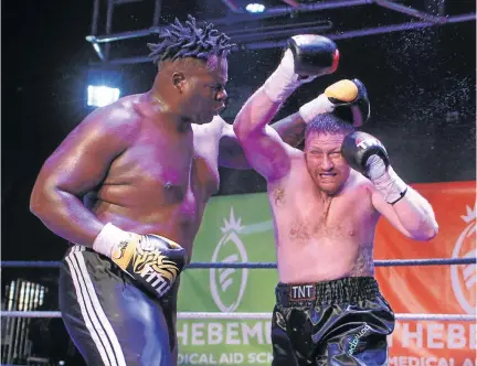 ?? / CHRISTO SMITH/ PICASA ?? Peto Kapela of the Congo and South African Greg Oliver exchange leather in their heavyweigh­t bout which Oliver won on points in Boksburg on Sunday.