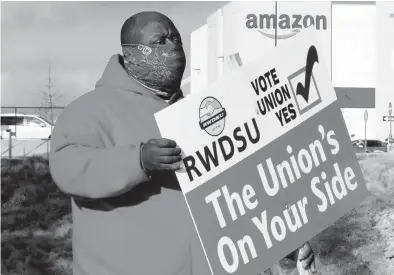  ?? JAY REEVES/AP ?? Michael Foster holds a sign outside an Amazon warehouse where labor is trying to organize workers in Bessemer, Alabama.