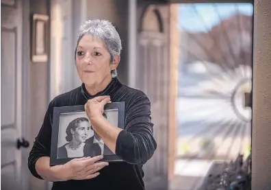  ?? ROBERTO E. ROSALES/JOURNAL ?? Ana Bell Ortiz, sister of Army Pfc. Jasper Marquez, holds a portrait of their mother, Domitilia Ortiz. Marquez was killed during the Korean War. His remains were identified in August after being returned to the U.S.