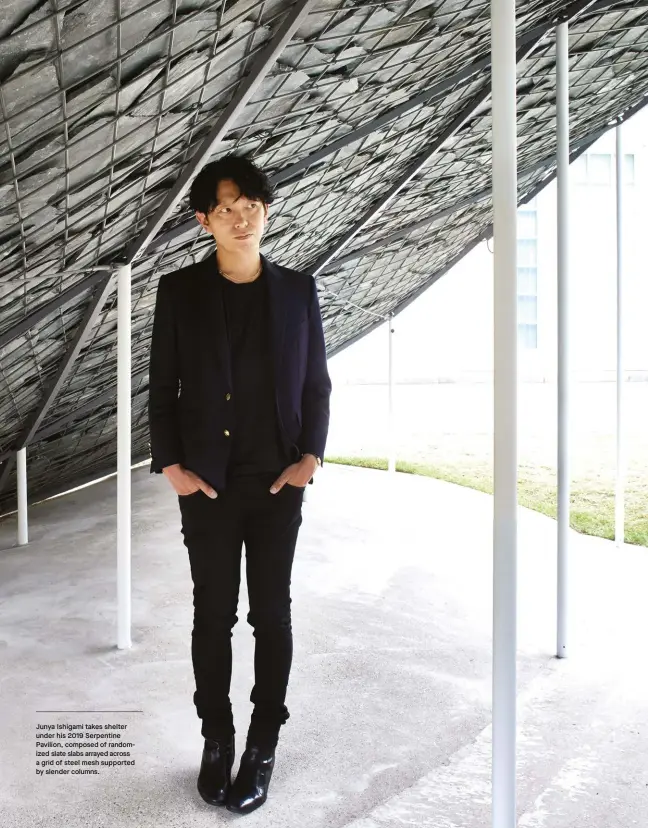  ??  ?? Junya Ishigami takes shelter under his 2019 Serpentine Pavilion, composed of randomized slate slabs arrayed across a grid of steel mesh supported by slender columns.