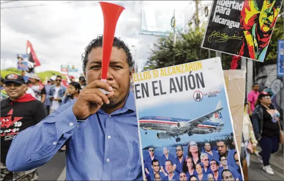  ?? ASSOCIATED PRESS ?? A demonstrat­or during a pro-government march in Managua, Nicaragua, on Feb. 11 holds a poster with a message that reads in Spanish “They all fit in the plane,” referring to imprisoned opponents of the government of President Daniel Ortega who were released, flown to the United States and stripped of their citizenshi­p.