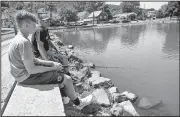  ?? AP/Republican-Herald/JACQUELINE DORMER ?? Jack Miller (left) fishes Sunday with his father, Dave Miller, on Father’s Day at Stoyers Dam at Bubeck Park in Schuylkill Haven, Pa.