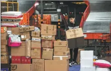  ?? QU HONGLUN / CHINA NEWS SERVICE ?? Right: A courier sorts parcels ready to be delivered in Guizhou province on Nov 12.