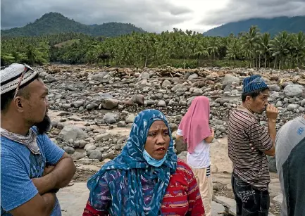  ??  ?? Residents look at what is left of their village in Salvador, Lanao del Norte province after Typhoon Tembin swept across the southern Philippine­s.