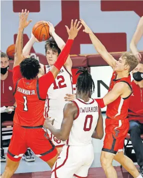  ?? [AP PHOTO/ GARETT FISBECK] ?? Oklahoma's Austin Reaves, middle, looks to pass the ball as Texas Tech's Terrence Shannon Jr., left, and Mac McClung, right, defend on Tuesday. Texas Tech won 69-67.