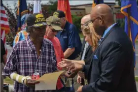  ??  ?? U.S. Marine Corps and Vietnam War Veteran Arthur Lee Hines of Lorain receives a commemorat­ive pin and copy of a commemorat­ive proclamati­on from Tony Milons, director of the Cleveland VA Regional Office, during an event by the Lorain Veterans Affairs...
