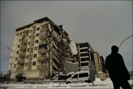  ?? EMRAH GUREL — THE ASSOCIATED PRESS ?? A man passes by a collapsed building in Malatya, Turkey, Tuesday.