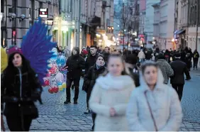  ?? SEAN GALLUP GETTY IMAGES FILE PHOTO ?? People stroll through the city centre of Lviv, Ukraine, last month. Located in the western part of the country, far from the current fighting raging between Ukrainian and Russian armed forces in the east, the city offers a sense of normalcy and is inviting tourists in an effort to support the embattled country’s economy.