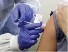  ?? Ted S. Warren, The Associated Press ?? A patient receives a shot in a clinical trial of a potential vaccine for COVID19. When a coronaviru­s vaccine finally becomes ready, the ability to deliver the lifesaving solution into the arms of Americans will require hundreds of millions of syringes.