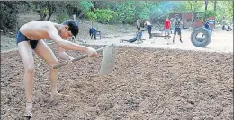  ?? KESHAV SINGH/HT ?? A young wrestler tilling the soil to prepare the akhada near Sukhna Lake in Chandigarh. During the lockdown, this practice was put on a hold for the first time in nearly 50 years.